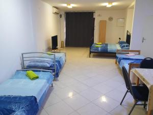 a room with three beds and a table and chairs at Apartment Stari Grad in Trebinje
