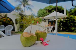 two green coconuts sitting on top of a table at Casa das Ondas Guarajuba in Guarajuba