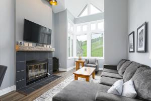 a living room with a couch and a fireplace at Chateau Ridge Chalet with Mountain View in Blue Mountains