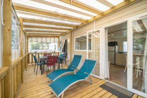 a screened porch with blue chairs and a table at Camping Les Genêts in Saint-Jean-de-Monts