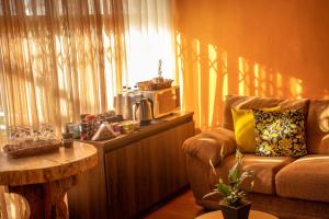 Pousada Recanto Aparados da Serra في كامبارا: غرفة معيشة مع أريكة وطاولة ونافذة