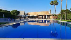 une grande piscine d'eau bleue devant un bâtiment dans l'établissement Ca la Victòria, à Vinyols i els Arcs