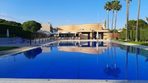 a large pool of blue water in front of a building at Ca la Victòria in Vinyols i els Arcs