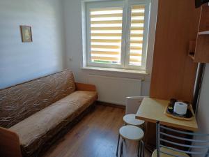 a living room with a couch and a table and a window at Pokoje Gościnne "Keja" in Dąbki