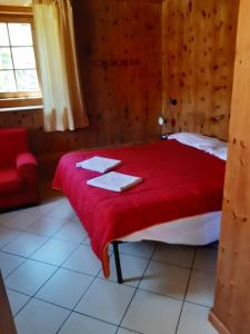 a bedroom with a bed with a red blanket at Appartamenti Joseff in Livigno