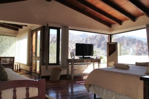 a bedroom with a bed and a television and mountains at Santa Lucia in Tilcara