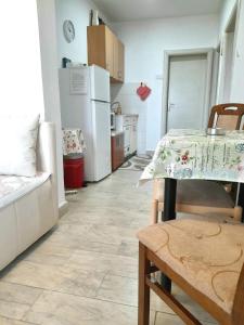 a kitchen with a table and a white refrigerator at Apartman SB in Ulcinj