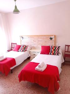 two beds in a room with red and white sheets at Casa de Antonio MURCHANTE in Murchante +44 photos