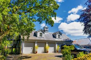 a house with a clock tower on top of it at Modern and Stylish WoodHous in Forfar