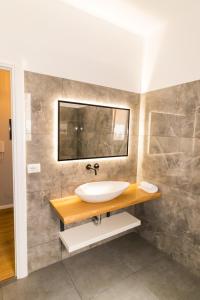 un baño con lavabo y espejo en Nikaj Premium Apart-Hotel, en Vlorë