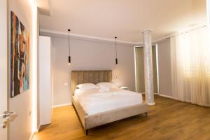 - une chambre avec un grand lit blanc dans l'établissement Nikaj Premium Apart-Hotel, à Vlorë