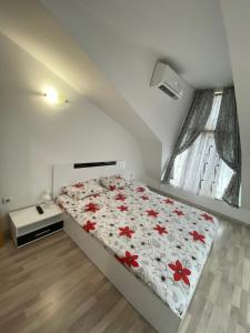 デヴィンにあるЛуксозен апартамент/ Lux apartmentのベッドルーム1室(赤い花のベッド1台付)