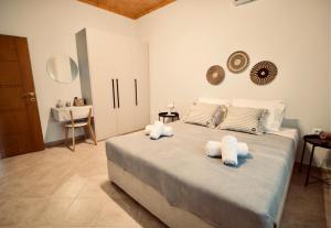 a bedroom with a large bed with towels on it at Enalio Beach House in Nea Kallikrateia