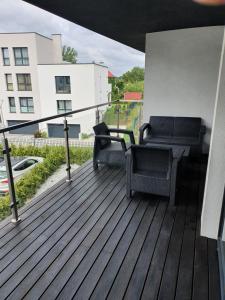 a deck with two chairs and a table on a building at Apartament Szyndzielnia in Bielsko-Biała