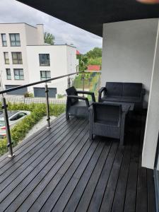 a deck with two chairs and a table on a building at Apartament Szyndzielnia in Bielsko-Biala