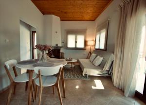 a living room with a table and chairs and a couch at Enalio Beach House in Nea Kallikrateia