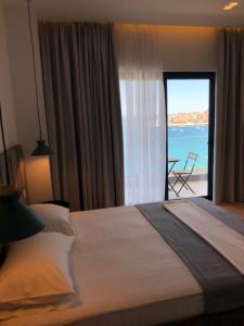 a bedroom with a bed and a view of the ocean at Kanes Bohemian Boutique Hotel in Sarandë +37 photos