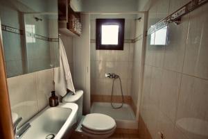 a bathroom with a toilet and a sink and a tub at Enalio Beach House in Nea Kallikrateia