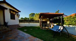 a swing in a yard next to a house at Enalio Beach House in Nea Kallikrateia