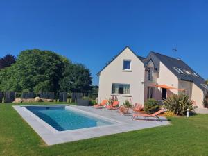 uma casa com piscina no quintal em Maison Spacieuse et lumineuse avec piscine privée et chauffée em Pordic