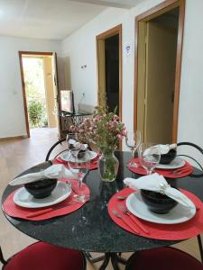 una mesa con servilletas rojas y copas de vino. en Casa de charme no clima de Pedra Azul en Domingos Martins
