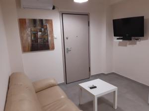 アテネにあるStylish apartmentのリビングルーム(ソファ、テレビ、テーブル付)