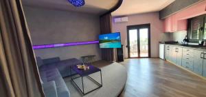 uma sala de estar com um sofá azul e uma televisão em Nina Apartment em Chania Town