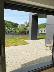 a window view of a patio with a chair at PENTHOUSE DURBUY APPART 10-12 Pers Vue Panoramique in Durbuy