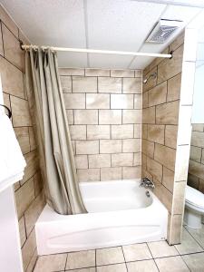 ein Bad mit einer Badewanne und einem WC in der Unterkunft Fairway Inn by the Falls in Niagara Falls