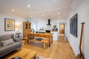 een woonkamer met een tafel en een bank bij Spacious & Stylish StoneHous Cottage in Forfar