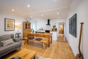a living room with a table and a couch at Spacious & Stylish StoneHous Cottage in Forfar