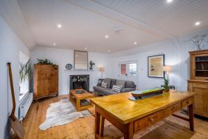 een woonkamer met een tafel en een bank bij Spacious & Stylish StoneHous Cottage in Forfar