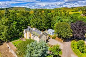 - une vue aérienne sur une grande maison dans les bois dans l'établissement Spacious & Stylish StoneHous Cottage, à Forfar