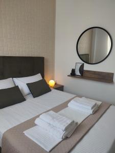 1 dormitorio con 1 cama blanca grande y espejo en Olive House, en Moírai