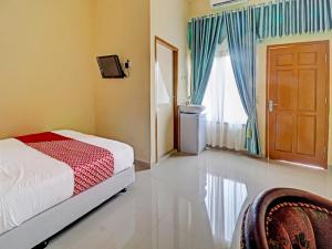 Tempat tidur dalam kamar di OYO 90945 Arizon Kost