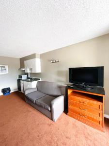 uma sala de estar com um sofá e uma televisão de ecrã plano em Fairway Inn by the Falls em Cataratas do Niágara