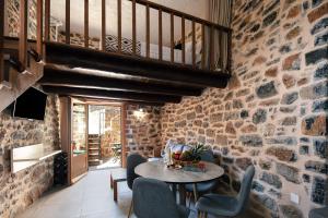 a stone walled room with a table and chairs at Palio Damnoni House in Damnoni