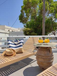 a wooden bench with a table and a hat and two oranges at Casa Centrale in Apollonia