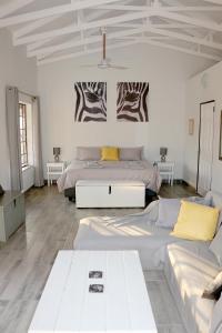 a white room with two beds and a couch at Villa de Leeu, Perfect for Two in Marloth Park