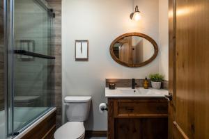 a bathroom with a toilet and a sink and a mirror at Le Boisé (Les Manoirs) Mont-Tremblant in Mont-Tremblant