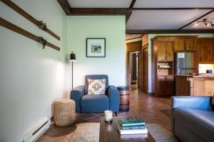 a living room with a couch and a table at Le Boisé (Les Manoirs) Mont-Tremblant in Mont-Tremblant