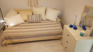 a small room with a bed with pillows and a night stand at Alex Seaview House in Chorefto