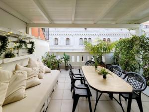 バーリにあるPenthouse in the heart of Bari with terraceのバルコニー(テーブル2台、椅子、植物付)