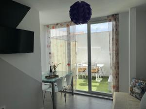 a room with a table and a dining room with a window at Alojamiento Turístico Un Mar De Olivos Jaén in Jaén