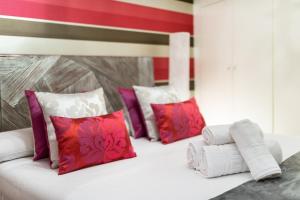 a white bed with purple and red pillows at Precioso apartamento en el centro de Granada in Granada