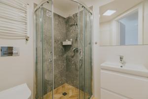a bathroom with a glass shower and a sink at FAMILKA in Karwia +24 photos
