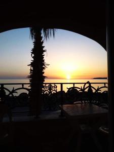 a view of the sunset from a balcony with a table at Apartmets Flisvos in Kalyves