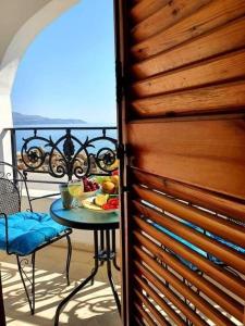 a table with a plate of fruit on a balcony at Apartmets Flisvos in Kalyves +5 photos