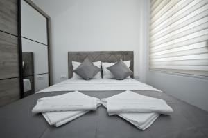 a bedroom with a bed with two towels on it at IgMAN apartments Tivat in Tivat