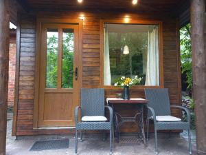 - une terrasse couverte avec une table, des chaises et une porte dans l'établissement LejasVāgneris, à Tukums